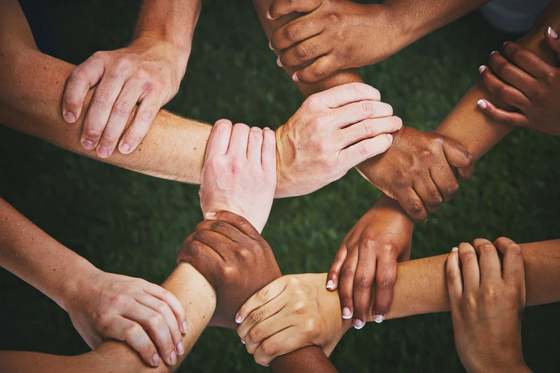 About many hands clasp wrists forming human chain